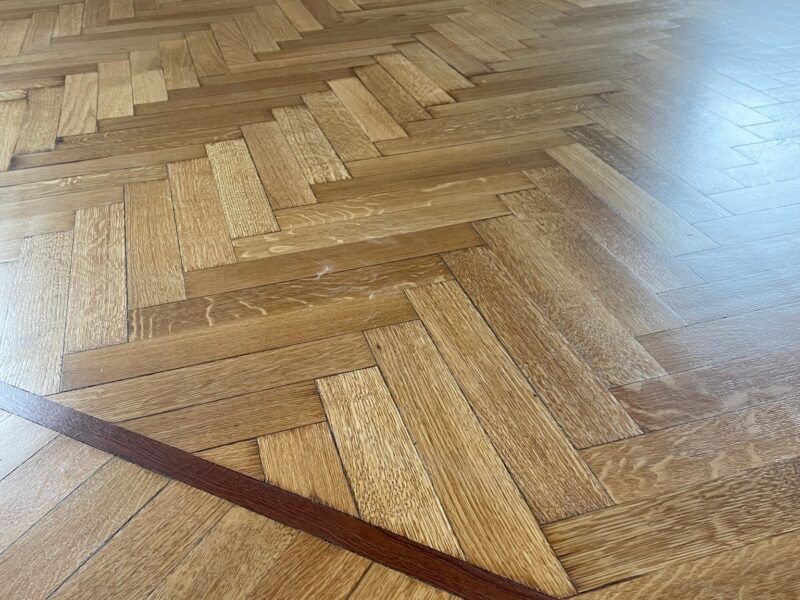 Parquet a spina di pesce restaurato con bordatura decorativa