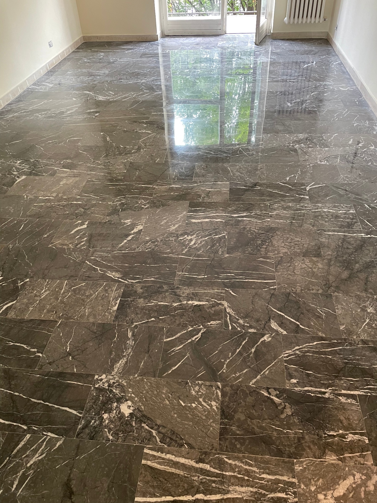 Pavimento in marmo grigio lucidato con riflesso della luce naturale